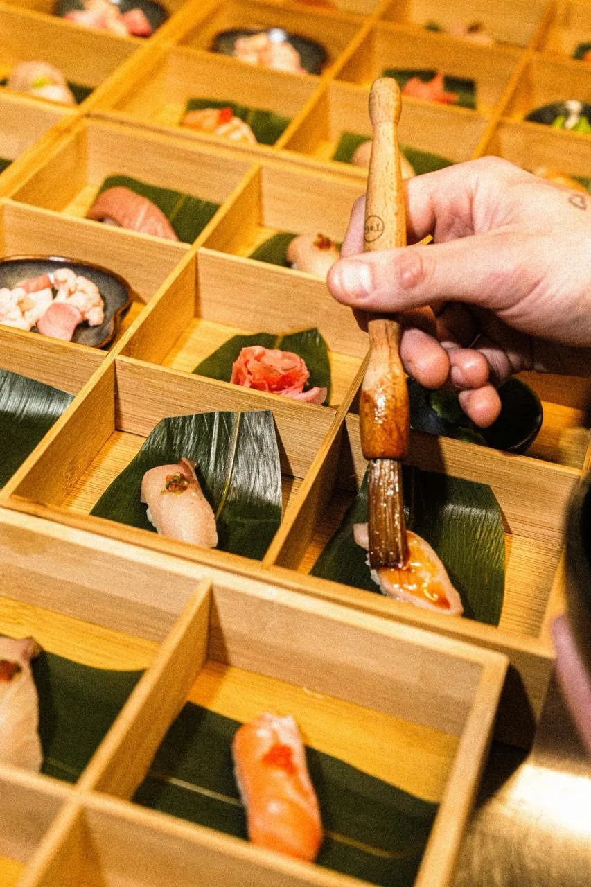 Käsi kannab pintsliga sushile kastet